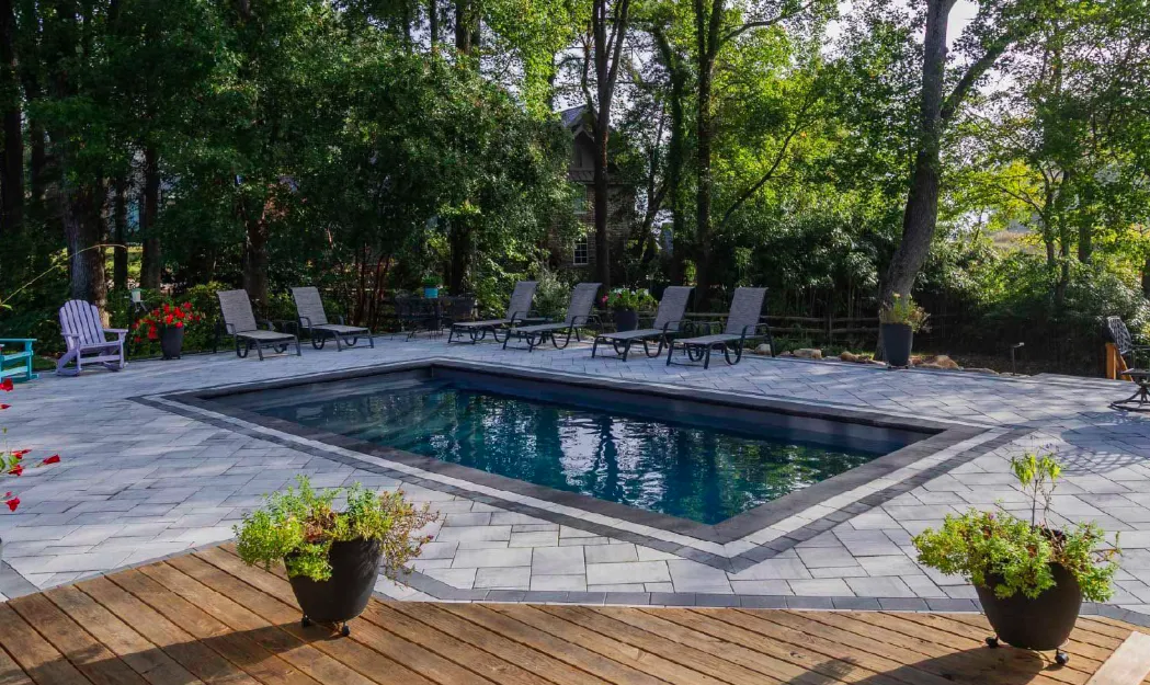 Bliss 30 fiberglass pool with Storm gray Unilock smooth pavers and bullnose coping — Capital Land Companies